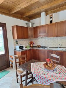 une cuisine avec des placards en bois et une table avec une table dans l'établissement Casa Vacanze Pianoneve, à Case dʼAmico
