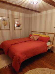 Schlafzimmer mit einem Bett mit einer roten Bettdecke in der Unterkunft Gemütliches Studio-Apartment in Ostseenähe - Cosy Wulfi in Probsteierhagen