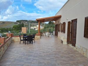 a patio with a table and chairs on a building at Case Vacanza Pianoneve in Buseto Palizzolo