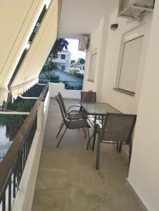 uma varanda com uma mesa e cadeiras num edifício em PortoHeli Matilda`s house 2 em Porto Heli