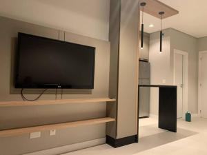 a living room with a flat screen tv on a wall at Apto inteiro 2 quartos, condomínio com piscina aquecida in Bombinhas