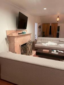 sala de estar con sofá y chimenea en ৎ୭ Spacious Retreat in Los Angeles ৎ୭, en Glendale