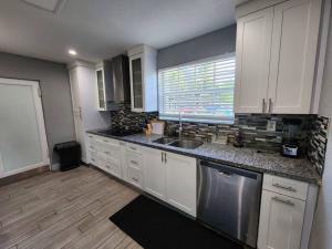 a kitchen with white cabinets and a sink and a window at The Perfect Vacation Getaway ! in Miami