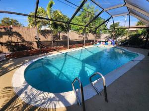 een groot blauw zwembad met een helder dak bij The Perfect Vacation Getaway ! in Miami