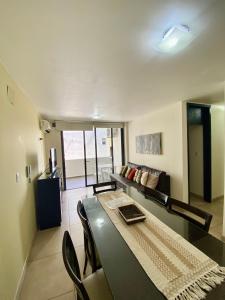 una sala de estar con una mesa y un sofá en Dpto Edificio Tempo, en Villa Carlos Paz