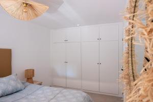 Schlafzimmer mit weißen Schränken und einem Bett in der Unterkunft Casa Molar in Altea