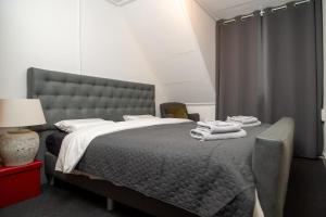 a bedroom with a large bed with towels on it at Sfeervol verblijf nabij centrum Almelo in Almelo