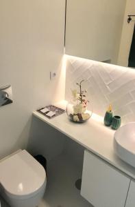 a white bathroom with a toilet and a sink at Studio Jardim São Lázaro in Porto