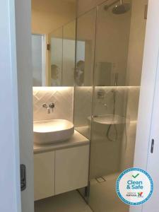 a white bathroom with a sink and a shower at Studio Jardim São Lázaro in Porto +14 photos
