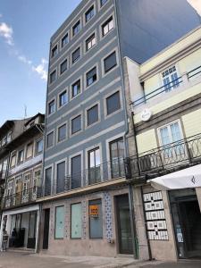 a tall gray building with a balcony on a street at Studio Jardim São Lázaro in Porto