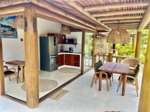a kitchen and dining room with a table and chairs at Chalé Del Mar in Morro de São Paulo