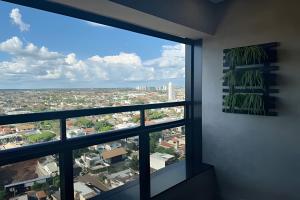 a room with a large window looking out at a city at Vertigo 243 - Gestão FGibran. in Campo Grande