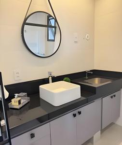W łazience znajduje się umywalka i lustro. w obiekcie Vertigo 243 - Gestão FGibran. w mieście Campo Grande