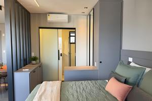 1 dormitorio con cama, escritorio y mesa en Vertigo 243 - Gestão FGibran. en Campo Grande