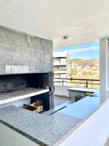 una cocina con chimenea de piedra en un edificio en Dpto Edificio Tempo en Villa Carlos Paz