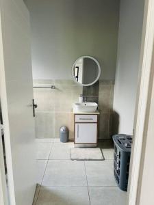 a bathroom with a sink and a mirror at Ekhaya Luxury Apartment in Lobamba