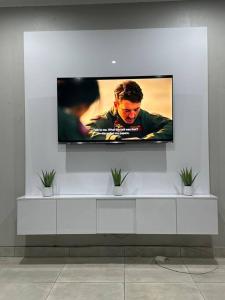 a flat screen tv on a white wall at Ekhaya Luxury Apartment in Lobamba