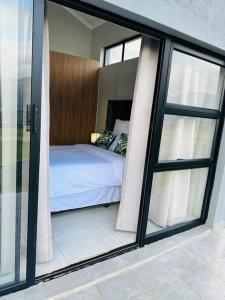 a bedroom with a bed and sliding glass doors at Ekhaya Luxury Apartment in Lobamba