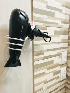 a black blow dryer hanging on a wall at CasAmalia in Florence