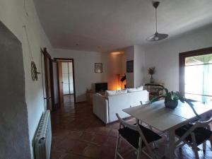 ein Wohnzimmer mit einem Tisch und einem weißen Sofa in der Unterkunft Ca l'Aleixa in Bisbal de Falset