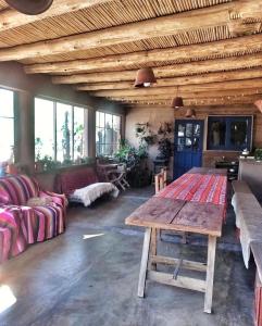 un ampio soggiorno con tavolo in legno e divano di El Cerrito a Maimará