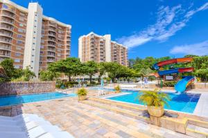 a swimming pool with a slide and some buildings at Império Romano Thermas - HUP CALDAS NOVAS in Caldas Novas