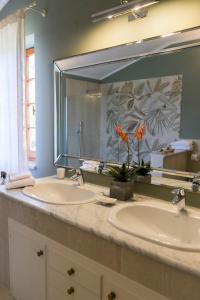 La salle de bains est pourvue de 2 lavabos et d'un grand miroir. dans l'établissement Casa Le Agavi, à Portoferraio