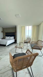 a hotel room with chairs and a bed and a bedroom at Hotel Presidente Beach Playas in Playas