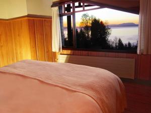 a bedroom with a bed and a window with a view at Cabañas Portal Pucon in Pucón