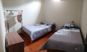 DEPARTAMENTO AMOBLADO 4 Camas 3 habitaciones في هانوكو: غرفة بسريرين وارضية خشبية