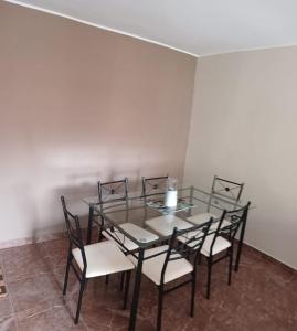 DEPARTAMENTO AMOBLADO 4 Camas 3 habitaciones في هانوكو: غرفة طعام مع طاولة وكراسي زجاجية
