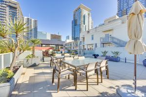 聖地牙哥的住宿－High-End San Diego Condo with Pool and Rooftop Access，庭院配有桌椅和遮阳伞。