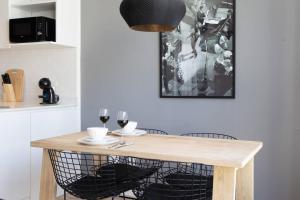 cocina con mesa de madera y 2 copas de vino en Enebro Beautiful Apartment en Buenos Aires