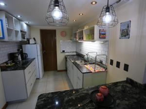 Una cocina con encimeras negras y electrodomésticos blancos. en Pinar suites, en San Carlos de Bariloche