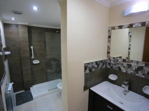 y baño con lavabo y ducha. en Pinar suites en San Carlos de Bariloche