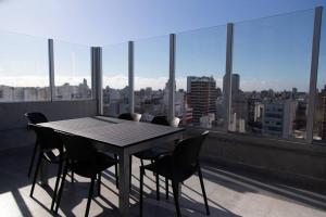een tafel en stoelen op een balkon met uitzicht op de stad bij Enebro Beautiful Apartment in Buenos Aires