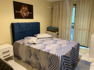 um quarto com uma cama com uma cabeceira azul em Apt. Luxo Cond.Mar de Conchas no Rio de Janeiro