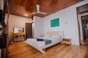 - une chambre avec un lit et un plafond en bois dans l'établissement Drop Inn Hostels, à Colombo