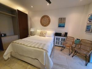 una camera da letto con un letto grande e due sedie di Las Palmas Joliet a Roatán