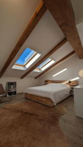 a bedroom with a bed and two skylights at Charming Barolo Wine Loft in Monforte dʼAlba