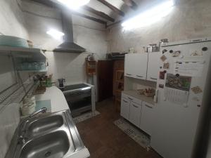 a small kitchen with a refrigerator and a sink at Ca l'Aleixa Rooms in Bisbal de Falset