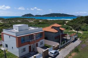 a house with a car parked in front of it at Casa de praia a 200 metros do mar in Florianópolis