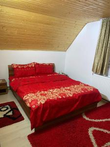 - une chambre avec un lit rouge et une couette rouge dans l'établissement Cabana Bradu Moșului, 