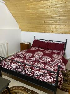 - une chambre avec un lit et une couette rouge dans l'établissement Cabana Bradu Moșului, 