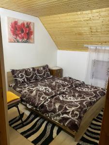 - une chambre avec un lit et une peinture murale dans l'établissement Cabana Bradu Moșului, 