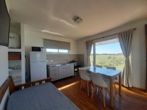 a kitchen and dining room with a table and chairs at Refugios de Marisol in Balneario Oriente
