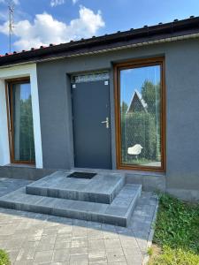 a house with a blue door and a window at Apartament przy Sali Kominkowej in Przeczyce