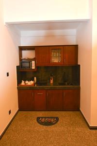 a kitchen with wooden cabinets and a microwave at Monkey Island Hotel in Hikkaduwa