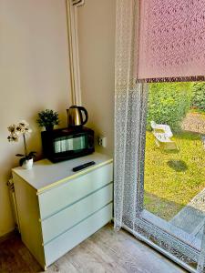 a dresser in a room with a window and a dresser with a dress at Apartament przy Sali Kominkowej in Przeczyce