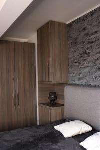 a bedroom with wooden cabinets and a bed with a pillow at Kula Apartman 3 in Brčko